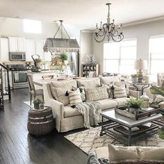 a living room filled with furniture and a chandelier hanging over the top of it