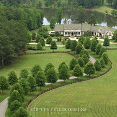 an aerial view of a large house in the middle of a lush green field with trees