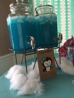 a table topped with jars filled with blue liquid and white fluffy clouds on top of it