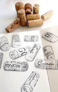 some wine corks are laying next to each other on a white surface with black ink