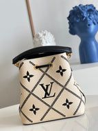 a white purse sitting on top of a table next to a blue vase and brush