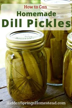 three jars filled with pickles sitting on top of a wooden table