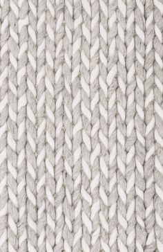 an up close shot of the texture of a knitted fabric with white and gray colors