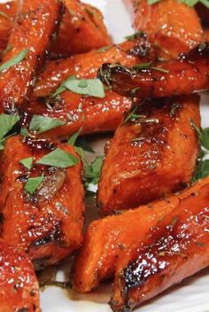 chicken wings covered in sauce and garnished with fresh herbs on a white plate