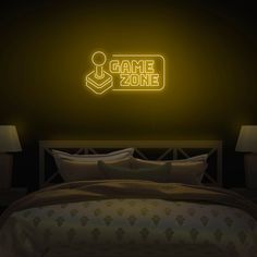 a neon sign that reads game zone on the wall above a bed in a dark room