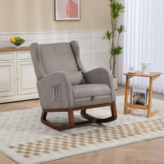 a rocking chair in a living room next to a coffee table and potted plant