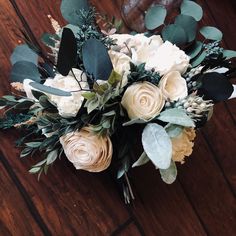 a bouquet of flowers sitting on top of a wooden table