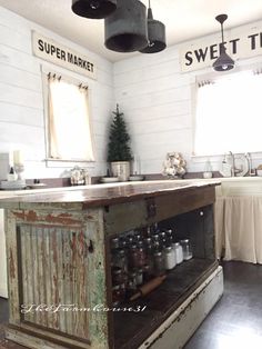 an old fashioned kitchen with lots of counter space and hanging lights above the island in front of the sink