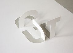 the letter g is cut out from paper and placed on top of a white surface