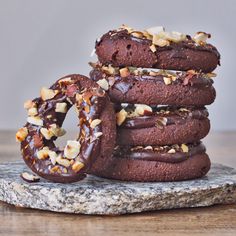 chocolate donuts stacked on top of each other with nuts and chocolate frosting in the middle