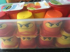 a plastic container filled with lots of different colored legos next to orange and yellow containers