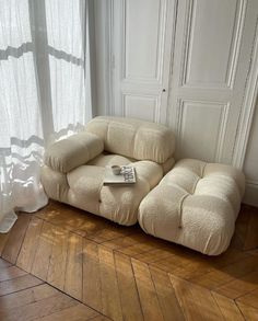 a couch sitting on top of a wooden floor next to a window