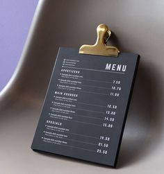 a menu hanging on the side of a chair with a clipboard attached to it