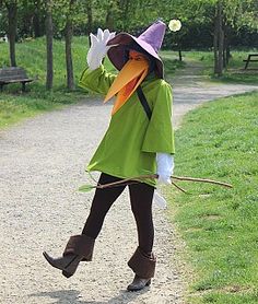 a woman dressed as a scarecrow walking down a path