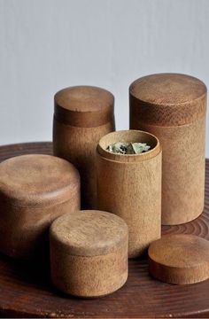 four wooden containers sitting on top of a table next to each other with money in them