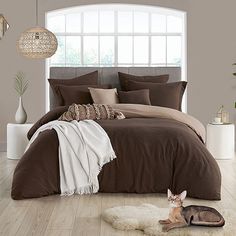 a large bed in a bedroom with brown and white comforter on top of it