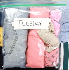 a bag filled with lots of clothes sitting on top of a table