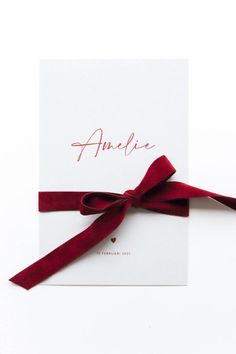 an envelope with a red ribbon tied around it and the word amelie written in cursive writing