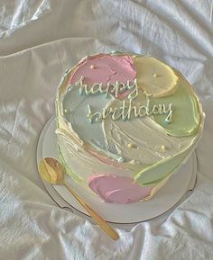 a birthday cake with the words happy birthday written on it and a spoon next to it