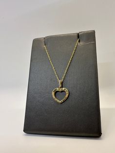 This open heart charm is made of 925 sterling silver with a 14K gold plating. It features simulated diamonds on the bail for some added sparkle. It comes paired with an 18" adjustable 14K gold plated silver cable chain. The heart features a diamond-cut design which allows the light to bounce off the pendant and shine beautifully.  * Stamped 925  * 14K Gold Plated * Diamond-Cut Design   * Adjustable chain 16" to 18"  * High Quality CZ Stones  * Heart measures 13mm w/o bail or jump   ring. * Heart Gold Heart Necklace With Hallmark, Gold Heart Necklace With Diamond Accents, Gold Open Heart Jewelry With Diamond Accents, Gold Sterling Silver Open Heart Necklace, Cubic Zirconia Open Heart Necklace In Fine Jewelry Style, Yellow Gold Heart Cut Birthstone Necklace, Gold Jewelry With Diamond Accents And Open Heart Shape, Gold Jewelry With Diamond Accents In Open Heart Shape, Heart Beads Open Heart Jewelry For Mom