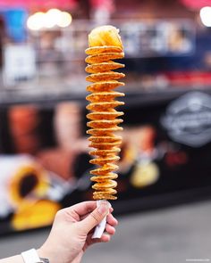 a person holding up a stack of fried food