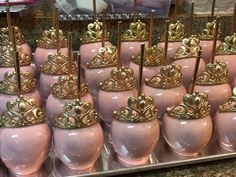 there are many pink vases with gold crowns on them