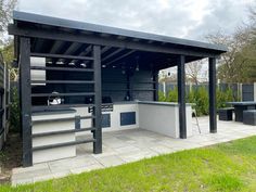 an outdoor bbq with grills and benches