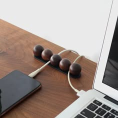 an apple laptop computer sitting on top of a wooden desk next to earbuds