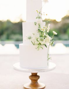 a white wedding cake with flowers on top