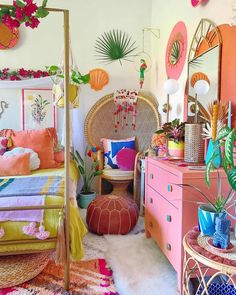 a bedroom decorated in pink, yellow and green with lots of tropical decor on the walls