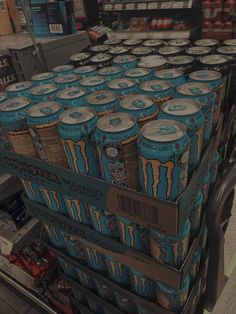 many cans of monster energy drink stacked on top of each other in a grocery store