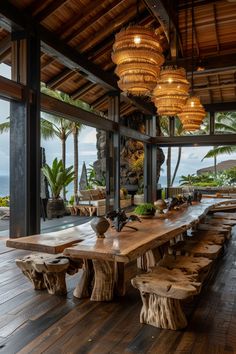 an outdoor dining area with wooden tables and benches, surrounded by large windows that look out onto the ocean