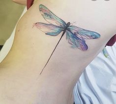 a woman's thigh with a tattoo of a dragonfly on her lower back