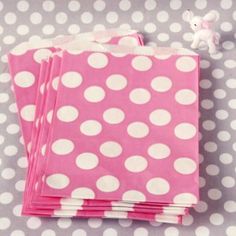 pink and white polka dot paper napkins stacked on top of each other with a teddy bear