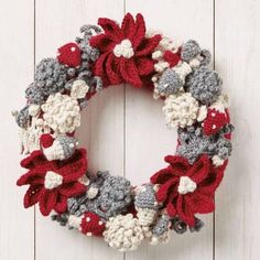 two crocheted wreaths hanging on the side of a white wooden wall next to each other