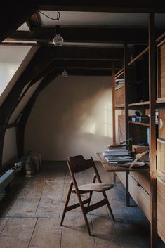 a chair sitting in the middle of a room next to a desk and bookshelf