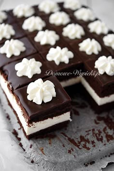 a chocolate cake with white frosting and flowers on top is cut in half to look like it has been sliced into squares