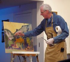 an older man is painting on the easel