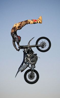 a man flying through the air while riding a motorcycle