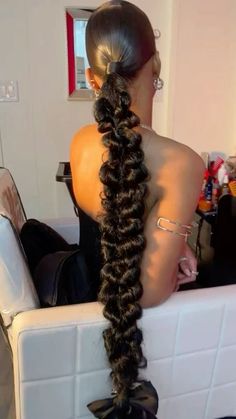 a woman with long hair sitting in a chair