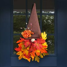 a fall wreath with a gnome's hat on the front door