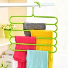 there is a green rack with towels hanging from it's sides and four folded ones on the other side