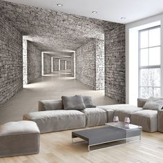 an empty living room with stone walls and floor to ceiling windows on either side of the couches