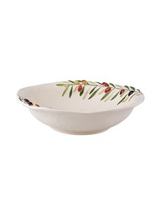 a white bowl with red berries and green leaves on the rim, against a white background