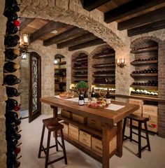 a wine cellar with several wooden barrels and bottles on the shelves, along with stools