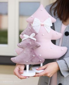 a woman holding a pink and white christmas tree