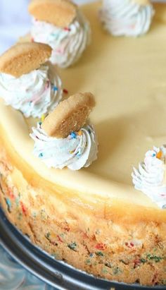 a cake with white frosting and cookies on top is sitting on a blue plate