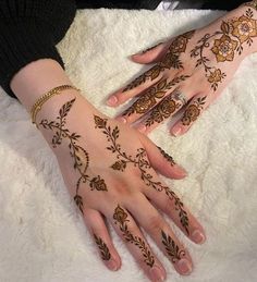 two hands with henna tattoos on them