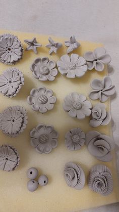 there are many different shapes and sizes of flowers on the cake sheet, as well as buttons