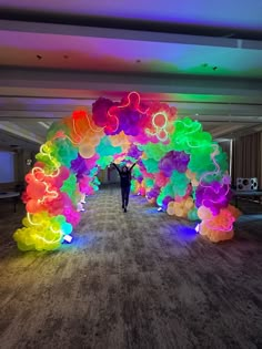 a person is standing under an arch made out of balloons